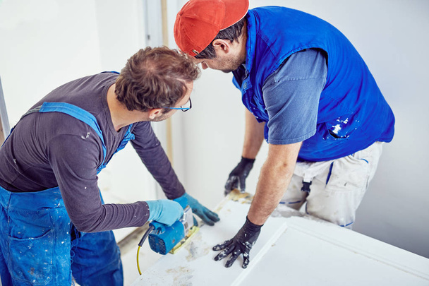 Two handymen working together on a house renovation. - Photo, Image
