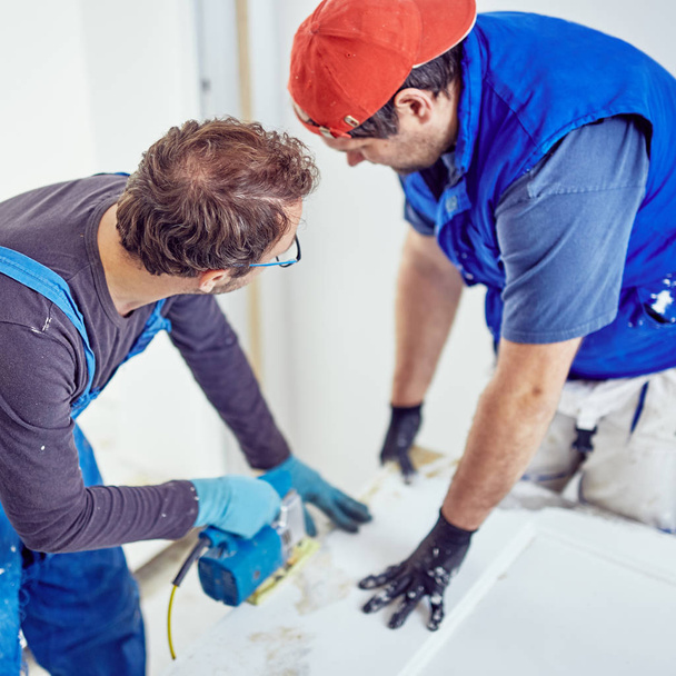 Zwei Handwerker arbeiten gemeinsam an einer Hausrenovierung. - Foto, Bild