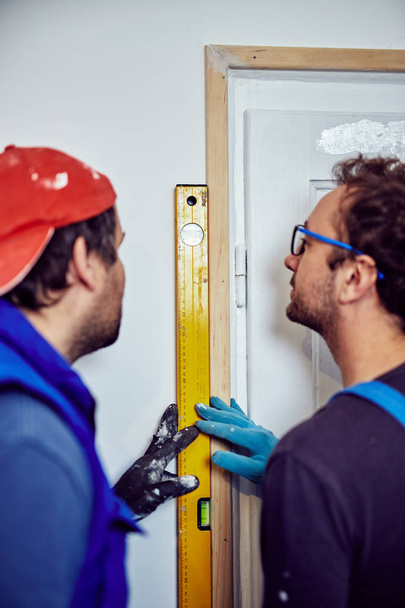 Two handymen working together on a house renovation. - Photo, Image
