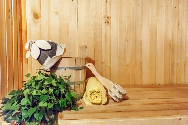 Interieurdetails Finse sauna stoomkamer badhuis met traditionele sauna accessoires bekken berk bezem Scoop vilt hoed handdoek - Foto, afbeelding