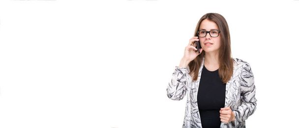 Smiling businesswoman in glasses talking on mobile phone. Beautiful young girl in Blazer on white isolated background talking on mobile phone. Woman in coat with cellphone. Copy space. Blank - Valokuva, kuva
