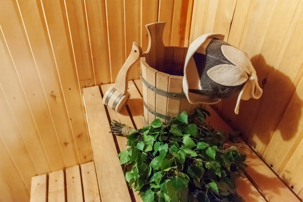 Szczegóły wnętrza sauna fińska łaźnia parowa z tradycyjną sauną akcesoria umywalka brzoza miotła miarka czuł kapelusz - Zdjęcie, obraz