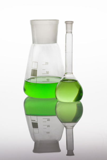 Set of laboratory glassware filled with vibrant liquids. - Фото, изображение