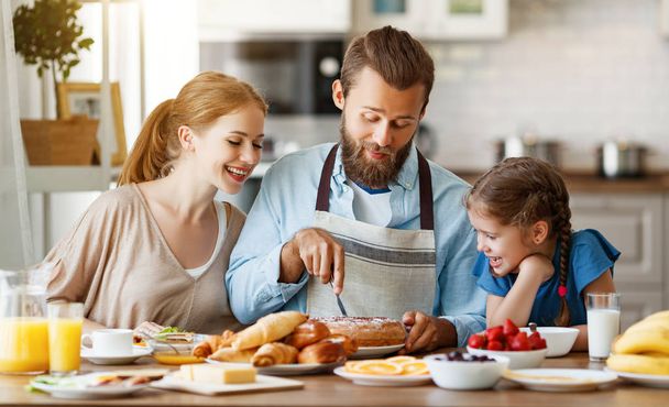 семья мать отец и ребенок дочь имеют завтрак на кухне
 - Фото, изображение