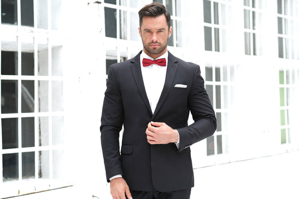 El look elegante es siempre el mejor. Hombre con traje negro y pajarita roja
. - Foto, Imagen