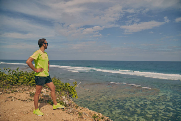 Sportler auf einer tropischen, exotischen Klippe in der Nähe des Ozeans. - Foto, Bild