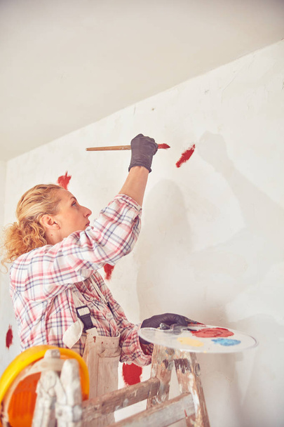 Trabalhador mulher reboco / pintura paredes dentro da casa
. - Foto, Imagem