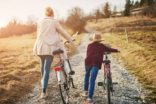 Мати і дочка з велосипедами на сільській місцевості
. - Фото, зображення