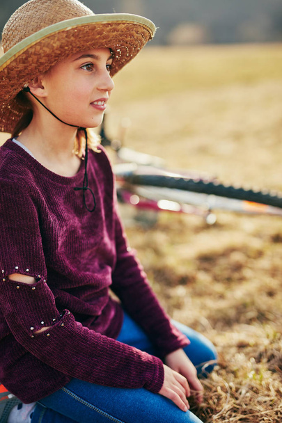 Cute little ten year old girl riding bicycle on countryside. - Foto, imagen