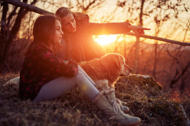 Gün batımında altın bir labrador ile anne ve kızı / gündoğumu t - Fotoğraf, Görsel