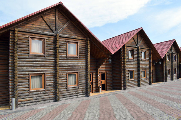 Case di legno. Mini hotel in legno su uno sfondo di cielo blu. Logge per una confortevole ricreazione all'aperto
. - Foto, immagini