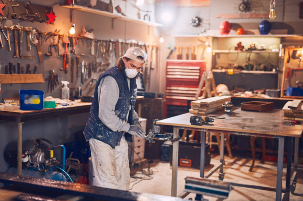 Männlicher Schreiner arbeitet in einer Retro-Werkstatt an altem Holz. - Foto, Bild
