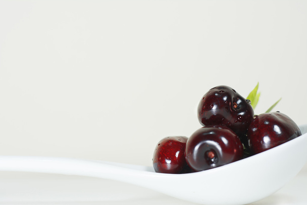 Cherries on white spoon - Fotó, kép