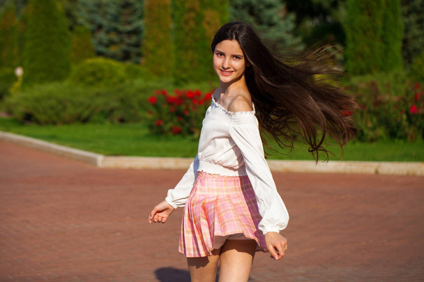 Pretty stylish brunette girl in plaid skirt and white blouse  - Fotó, kép
