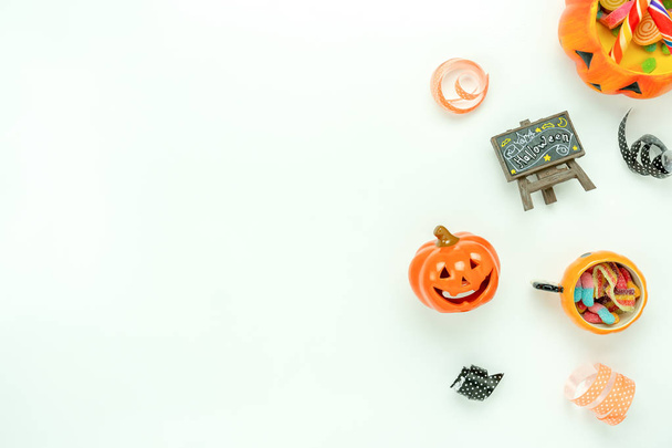 Table top view aerial image of decoration Happy Halloween day background concept.Flat lay accessories essential object to party the pumpkin & doll and candy on white wooden.Space for creative design. - Photo, image