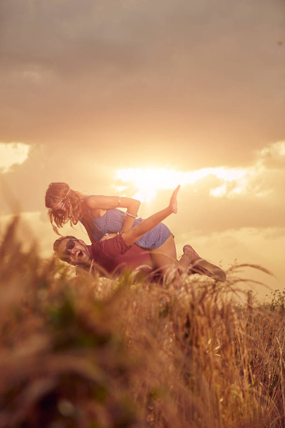 Couple au coucher / lever du soleil dans un champ de blé
. - Photo, image