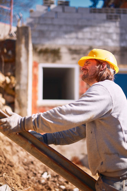 Trabajador de la construcción en un sitio pesado haciendo trabajo duro
. - Foto, Imagen