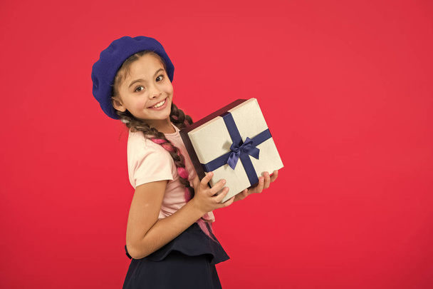 Guess what your child dream about. Best toys and christmas gifts. Kid little girl in beret hat hold gift box. Child excited about unpacking gift. Small cute girl received gift pack with ribbon bow - Photo, image