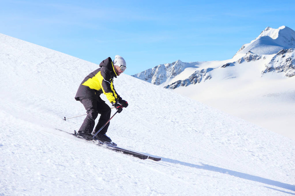 Alpine skier on piste running downhill - Zdjęcie, obraz