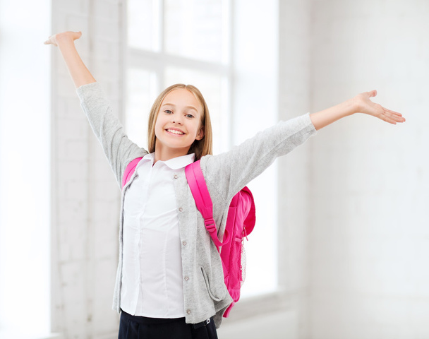 Student girl with hands up at school - Foto, Imagen