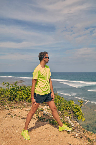 Urheilija venyttely trooppinen eksoottinen kalliolla lähellä merta
. - Valokuva, kuva