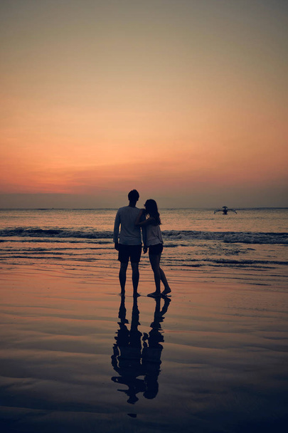 Silhouette d'une fille au coucher du soleil / lever du soleil sur l'océan
. - Photo, image