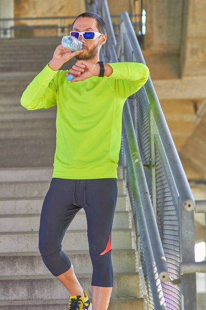 Deportista haciendo ejercicio / trotando en un gran puente urbano de la ciudad
. - Foto, Imagen