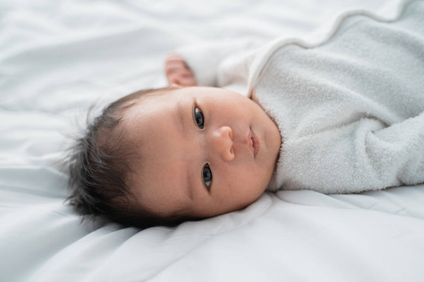 infant newborn baby on white bed - Foto, afbeelding