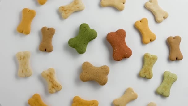  Roterende hond voedsel koekjes gevormd als botten. Close-up. - Video