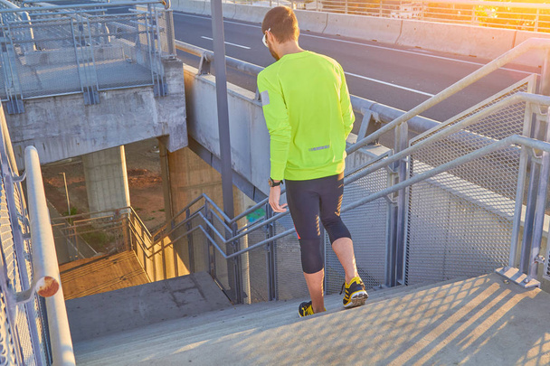 Un sportif s'entraîne / fait du jogging sur un pont urbain d'une grande ville
. - Photo, image
