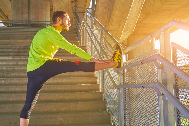 Un sportif s'entraîne / fait du jogging sur un pont urbain d'une grande ville
. - Photo, image