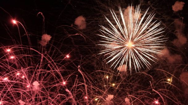 Blumengruß Hintergrund. Feuer blitzt auf und Rauch auf schwarz. Festliches Feuerwerk zum Jahrestag der Unabhängigkeit, Neujahr, Weihnachten, 4. Juli. - Foto, Bild