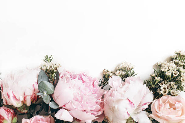 Banner decorativo de tela hecho de hermosas peonías rosadas, rosas y eucaliptos aislados sobre fondo blanco. Composición femenina del marco floral. Fotografía de stock de estilo.Espacio vacío. Piso tendido, vista superior
. - Foto, Imagen