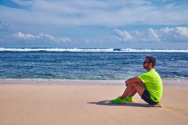 Deportista estirándose en una exótica playa tropical después de correr /
  - Foto, imagen
