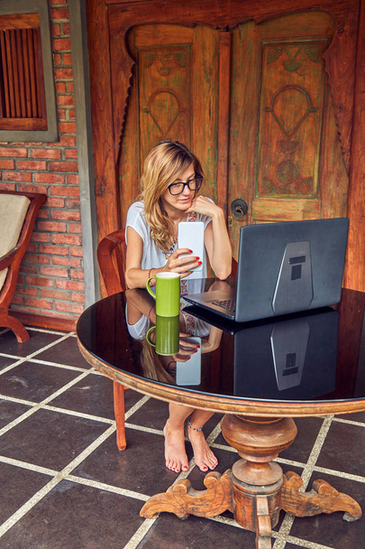 Akıllı telefon, kahve / çay ve dizüstü bilgisayar ile Freelancer kız bir ho - Fotoğraf, Görsel