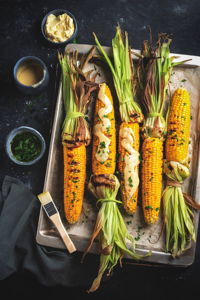 grilled corn on a baking sheet, top view, dark background, rustic style - Foto, Imagem