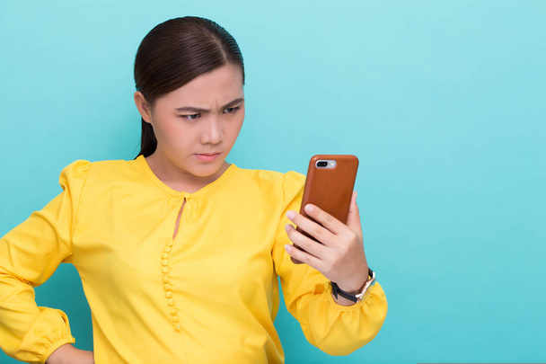 Woman use the smartphone and she feel angry - Photo, Image