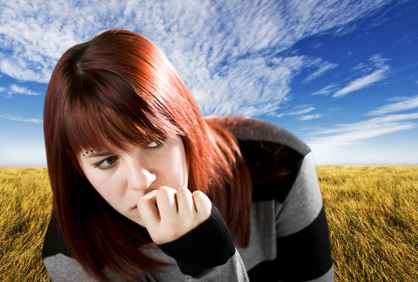 Pensive redhead girl biting nail - Photo, Image