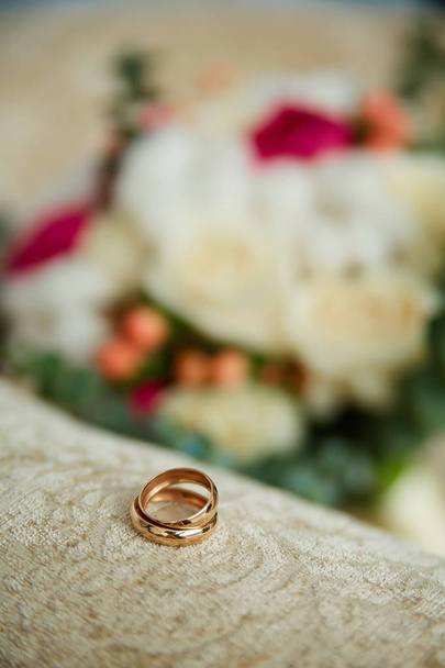gold wedding rings close-up on a beige background - 写真・画像