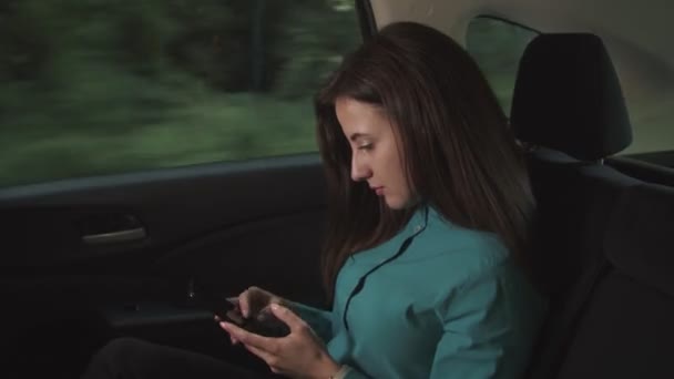 Businesswoman text messaging on cellphone in car - Imágenes, Vídeo