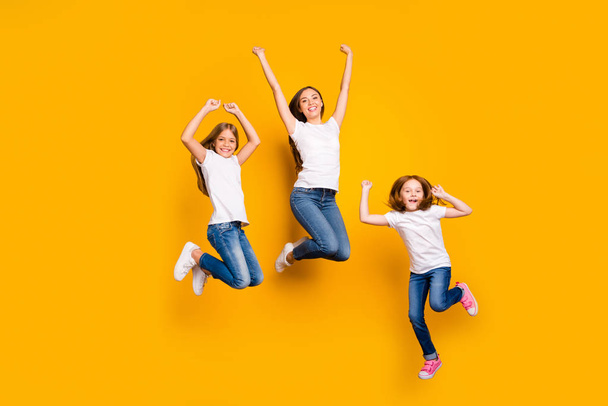 Full body photo of three ladies jumping high spending weekend wear casual clothes isolated yellow background - Foto, afbeelding
