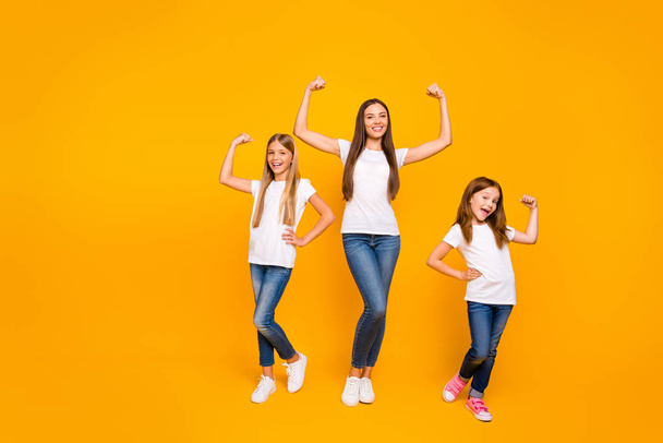 Full length photo of incredible three ladies showing power in arms wear casual clothes isolated yellow background - Foto, Imagem