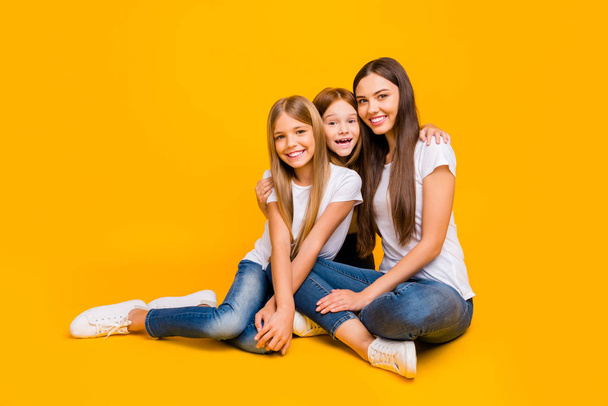 Full size photo of amazing three ladies sitting floor wear casual clothes isolated yellow background - Fotó, kép