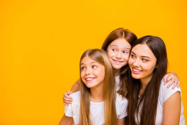 Photo of three amazing ladies of different age looking side empty space wear casual clothes isolated yellow background - Zdjęcie, obraz