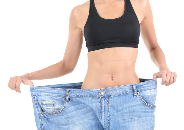 Slim girl in big jeans isolated on white - Fotó, kép