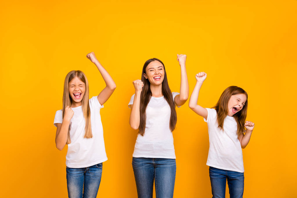 Photo of three different age ladies celebrating best win wear casual white t-shirts isolated yellow background - Foto, Bild