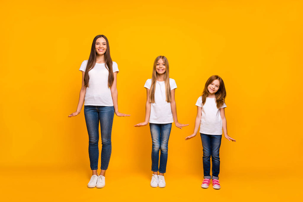 Full length photo of three sister ladies on fashion show wear casual outfit isolated yellow background - Fotografie, Obrázek
