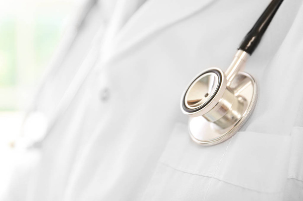 Male doctor with stethoscope in clinic, closeup - Photo, Image