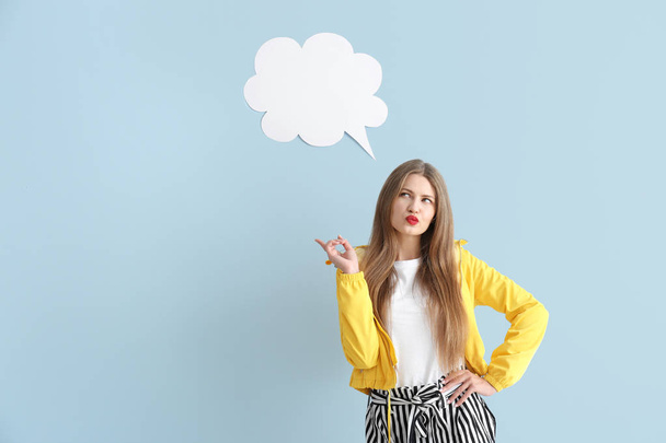 Thoughtful young woman with speech bubble on color background - Foto, imagen