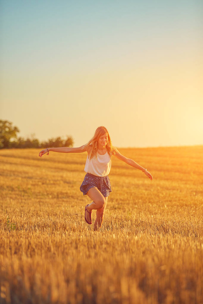 Mulher jovem bonito pulando em um campo de trigo
. - Foto, Imagem